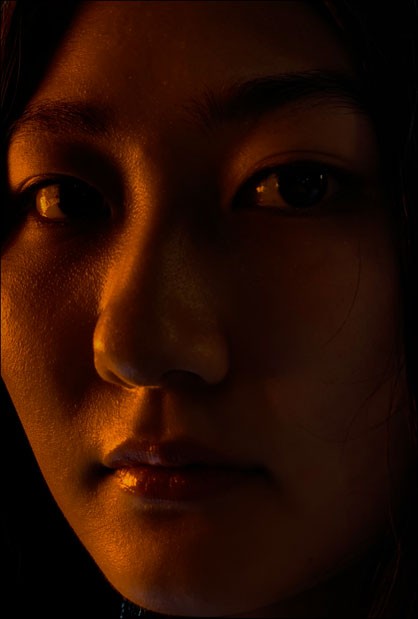 iPhone XS・iPhone XS Maxのデュアルカメラシステムで、暗い中、女性の顔面ズームアップした姿を写しだした画像
