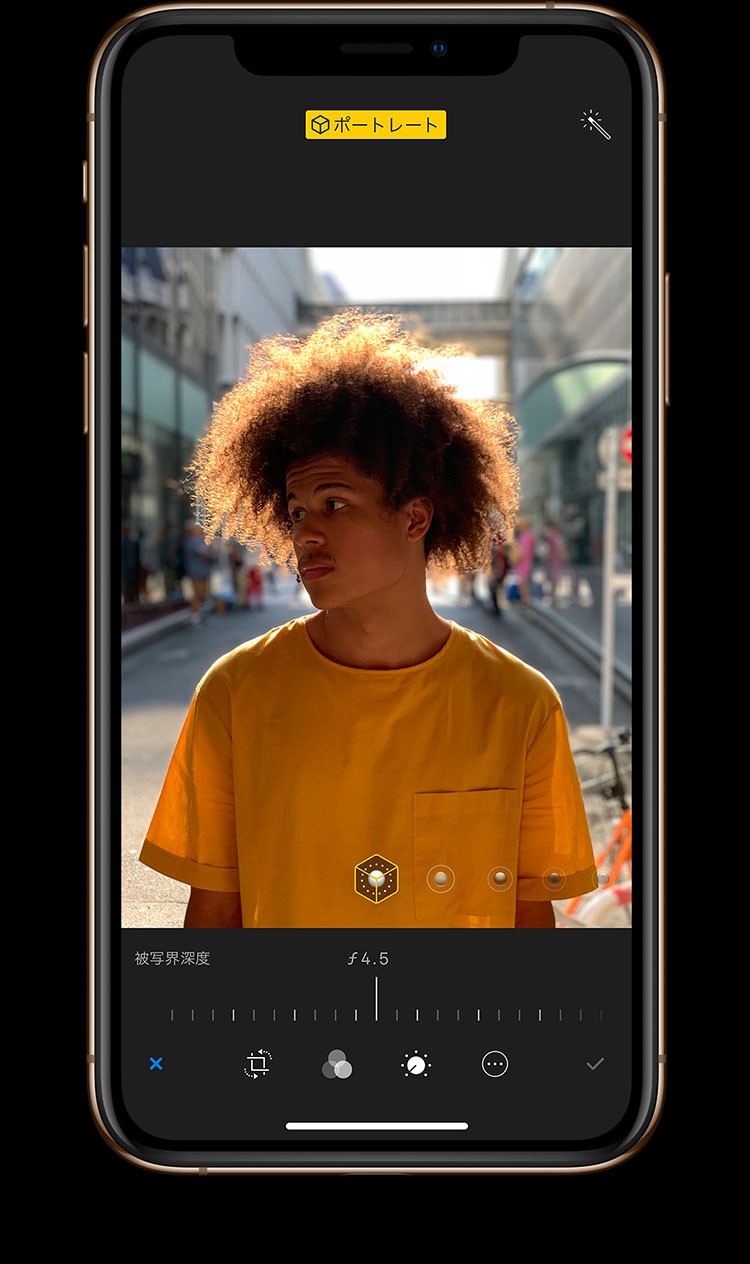 iPhone XS・iPhone XS Maxのデュアルカメラシステムの深度コントロールで、スパイラルパーマで黄色いTシャツを着た若い外国人男性を写した写真の被写界深度を調整している画像